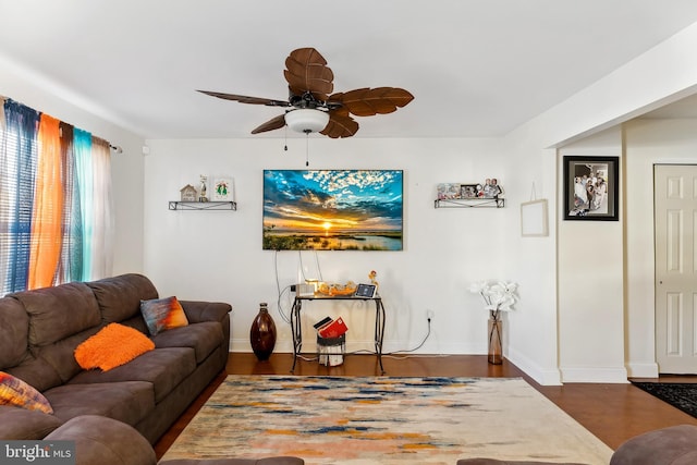 living room featuring ceiling fan and dark hardwood / wood-style floors