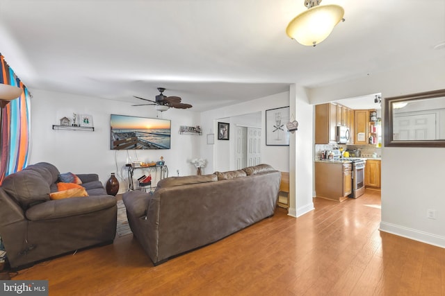 living room featuring ceiling fan and light hardwood / wood-style flooring