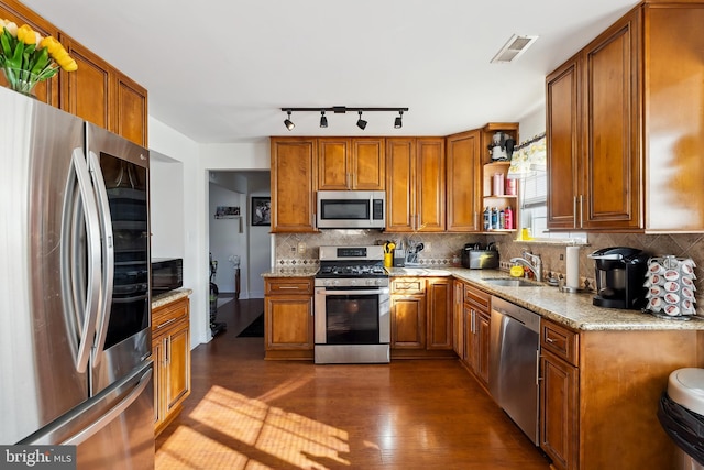 kitchen featuring backsplash, dark hardwood / wood-style flooring, sink, and stainless steel appliances