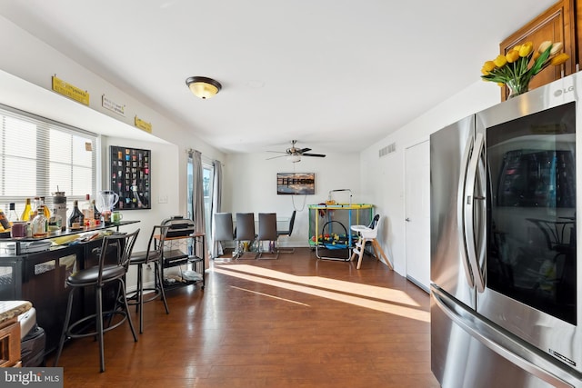 interior space with ceiling fan, dark hardwood / wood-style floors, and stainless steel refrigerator