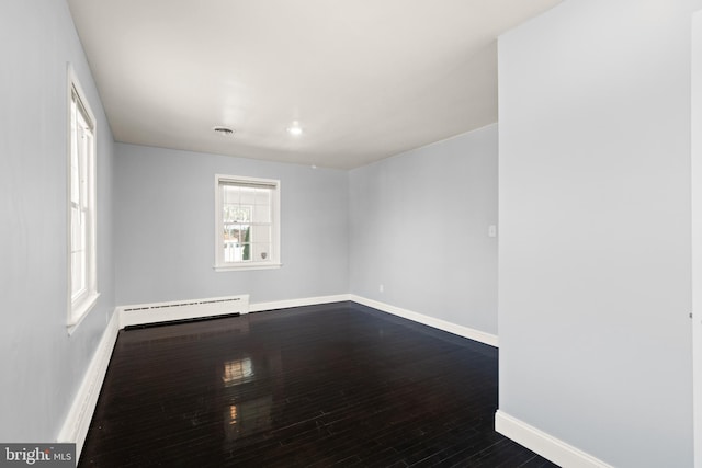 spare room featuring hardwood / wood-style flooring and a baseboard radiator