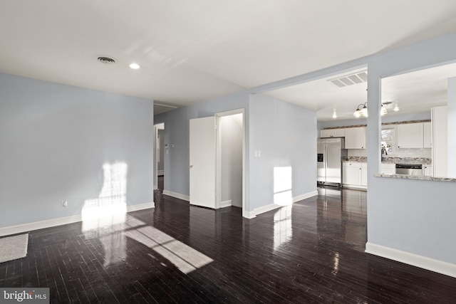 unfurnished living room featuring dark hardwood / wood-style flooring and sink