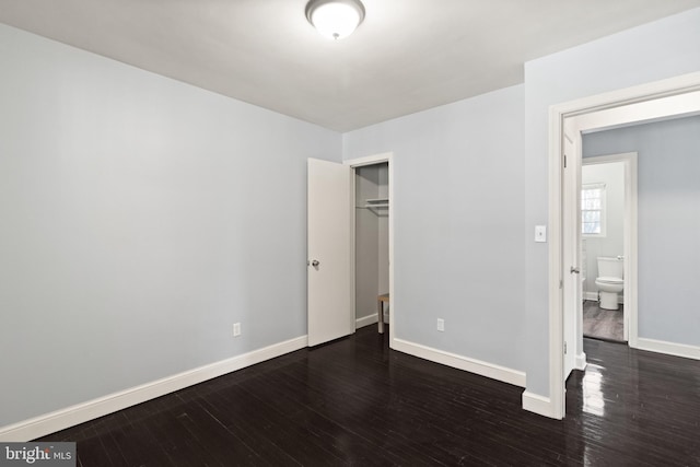 unfurnished bedroom featuring dark hardwood / wood-style floors and a closet