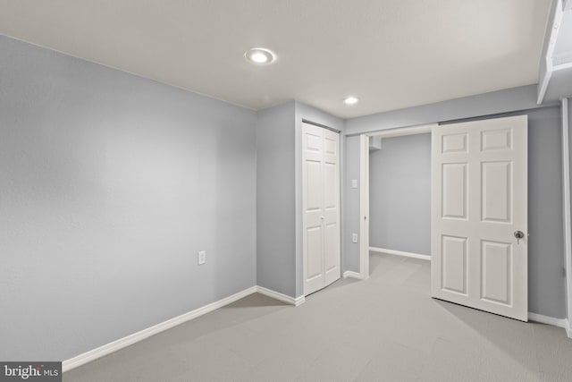 unfurnished bedroom featuring a closet and light colored carpet