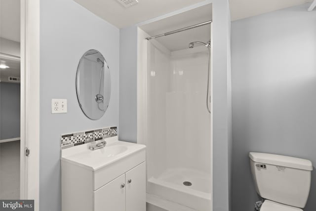 bathroom with toilet, vanity, backsplash, and a shower