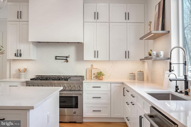 kitchen featuring sink, white cabinets, decorative backsplash, light stone counters, and stainless steel appliances