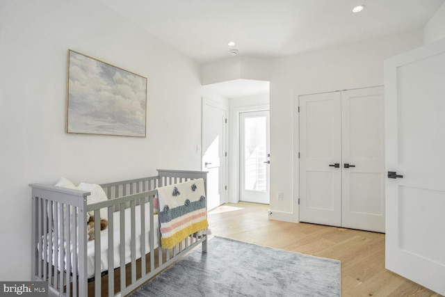 bedroom with light hardwood / wood-style flooring and a closet