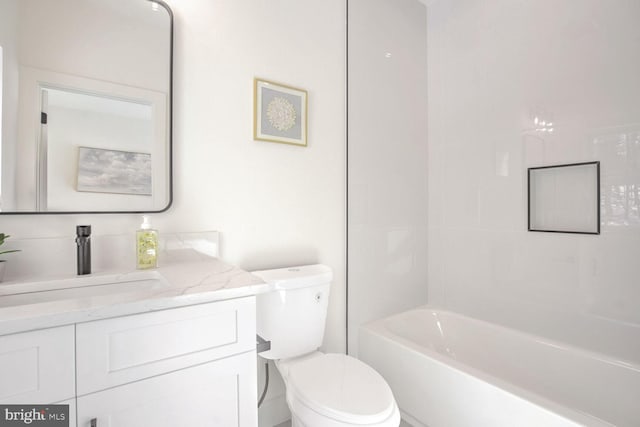 full bathroom featuring vanity, tiled shower / bath, and toilet