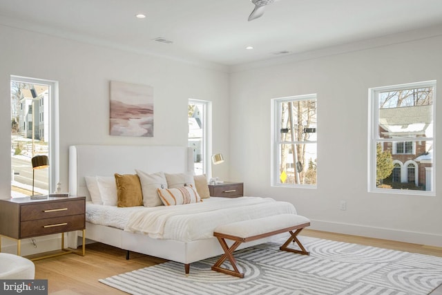 bedroom with crown molding and light hardwood / wood-style flooring