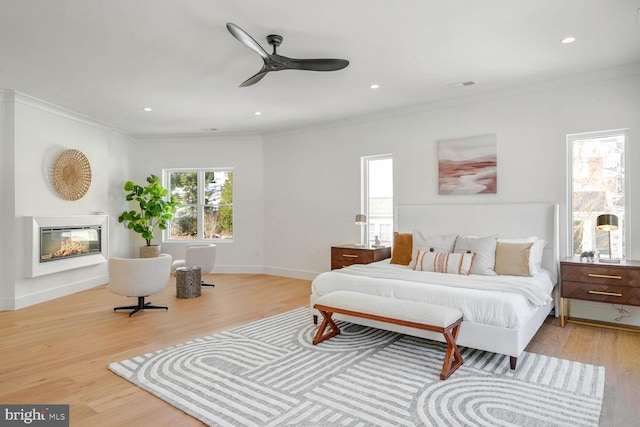 bedroom featuring ornamental molding, ceiling fan, and light hardwood / wood-style floors