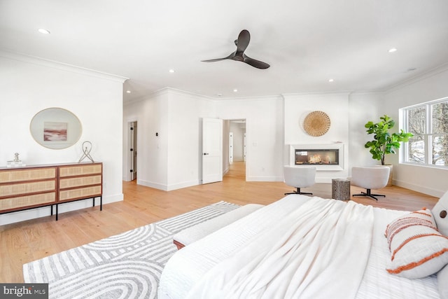 bedroom featuring crown molding, ceiling fan, and light hardwood / wood-style flooring