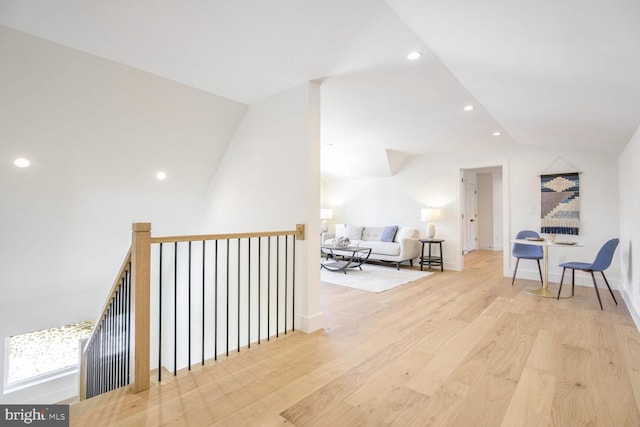 hallway featuring vaulted ceiling and light hardwood / wood-style floors