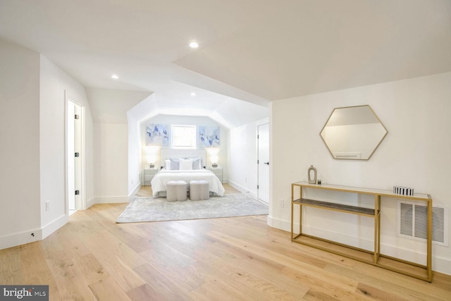 unfurnished bedroom with vaulted ceiling and light wood-type flooring