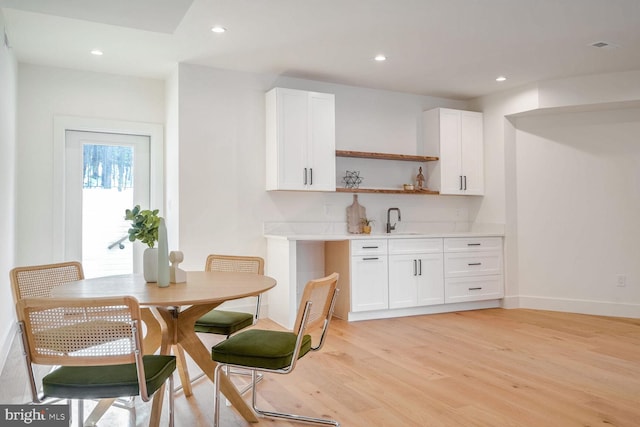 dining space with sink and light hardwood / wood-style floors