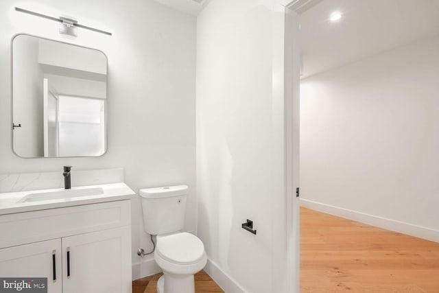 bathroom with vanity, hardwood / wood-style flooring, and toilet