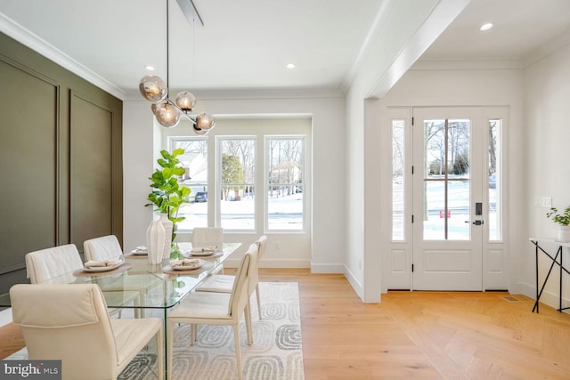 dining area featuring a notable chandelier, crown molding, light parquet flooring, and a healthy amount of sunlight