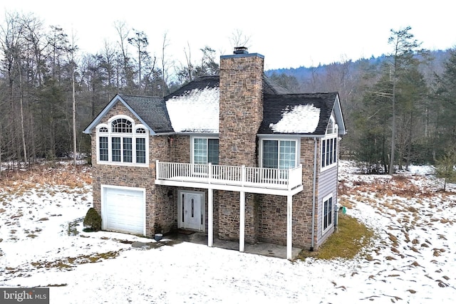 snow covered house featuring a garage