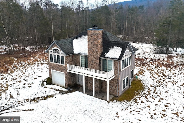 snow covered property with a garage