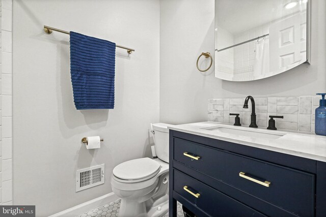 bathroom with tasteful backsplash, vanity, toilet, and walk in shower