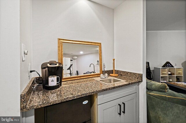 kitchen featuring sink and dark stone countertops