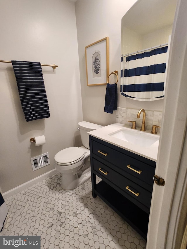 bathroom featuring vanity, backsplash, tile patterned floors, and toilet