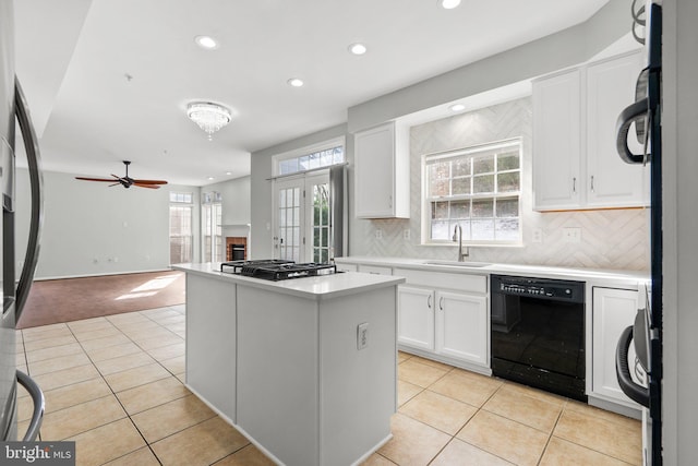 kitchen with sink, white cabinetry, appliances with stainless steel finishes, a kitchen island, and decorative backsplash