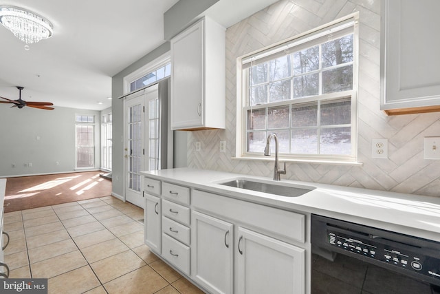kitchen with black dishwasher, sink, white cabinets, and light tile patterned floors