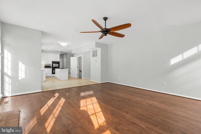 unfurnished living room with light hardwood / wood-style flooring and ceiling fan