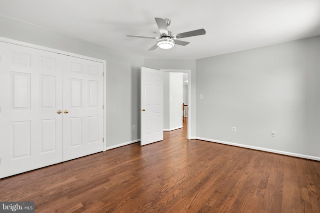 unfurnished bedroom featuring dark hardwood / wood-style flooring, ceiling fan, and a closet