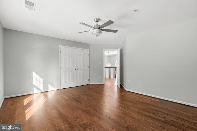 empty room with ceiling fan and dark hardwood / wood-style flooring