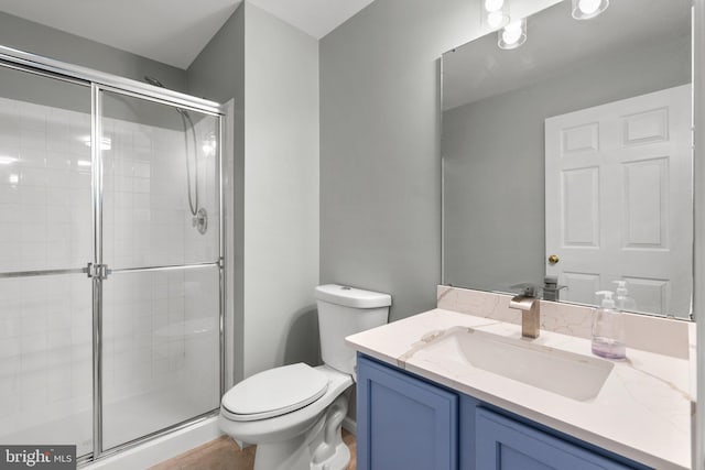 bathroom featuring an enclosed shower, vanity, tile patterned floors, and toilet