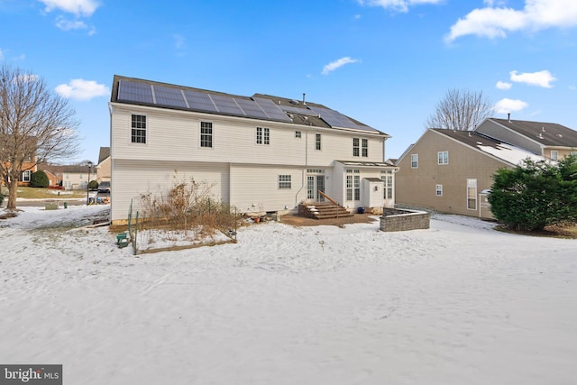 snow covered property with solar panels
