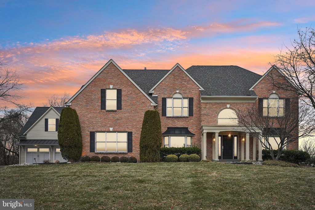 front facade featuring a garage and a yard