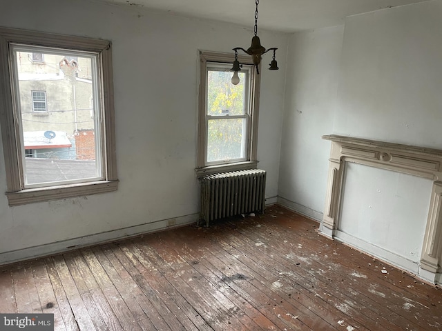 unfurnished dining area with radiator and hardwood / wood-style flooring