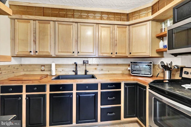 kitchen with appliances with stainless steel finishes, wooden counters, a sink, and open shelves