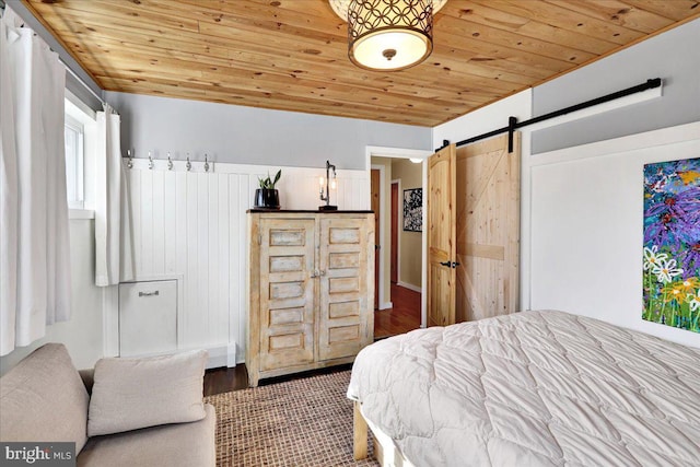 bedroom with a barn door and wooden ceiling