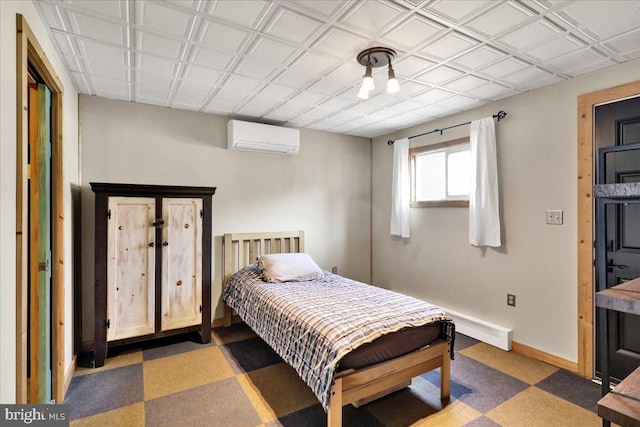 bedroom featuring baseboards, an AC wall unit, and tile patterned floors