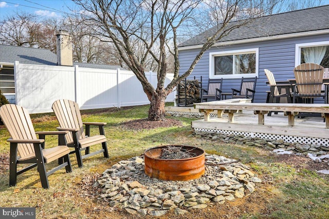 view of yard featuring fence, a fire pit, and a wooden deck