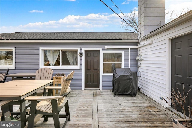 wooden terrace with outdoor dining space and area for grilling