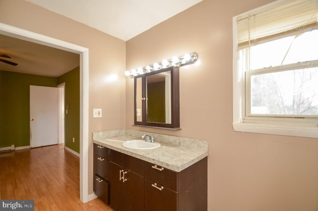 bathroom featuring ceiling fan, hardwood / wood-style floors, and vanity