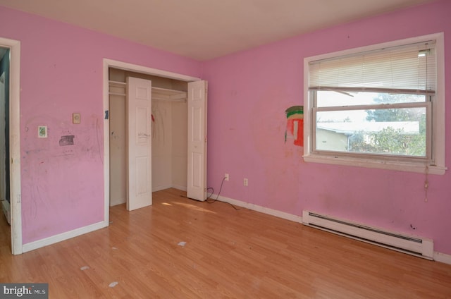 unfurnished bedroom with light wood-type flooring and a baseboard radiator