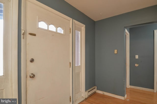 entryway with light hardwood / wood-style flooring and a baseboard radiator