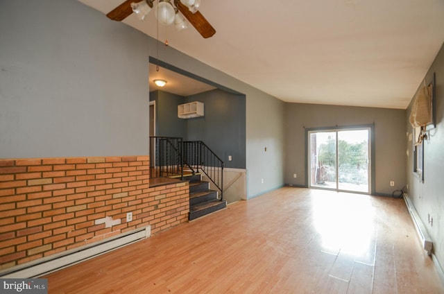 unfurnished living room with lofted ceiling, a baseboard heating unit, an AC wall unit, and light hardwood / wood-style flooring