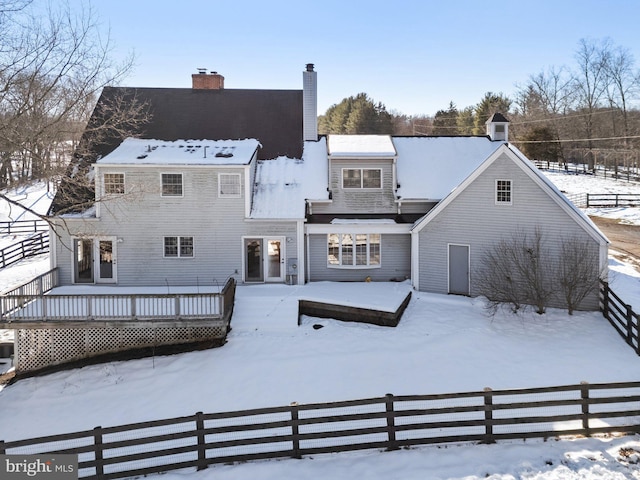 snow covered house featuring a wooden deck