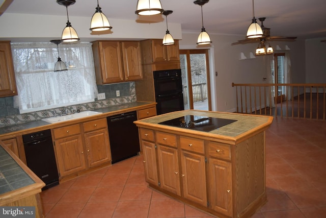 kitchen featuring a kitchen island, pendant lighting, sink, tile counters, and black appliances