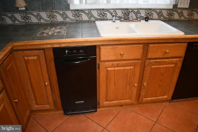 kitchen featuring tile patterned flooring, tile countertops, dishwasher, and sink