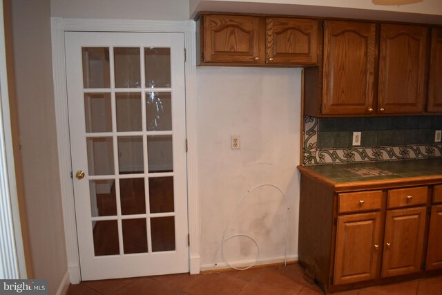 kitchen with tile patterned flooring and backsplash