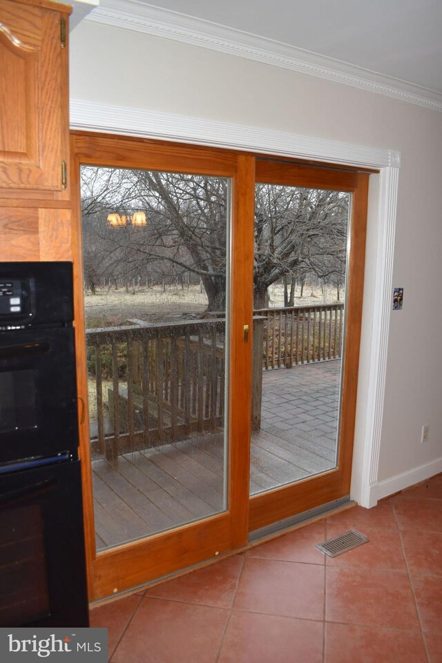 doorway to outside featuring tile patterned flooring and ornamental molding