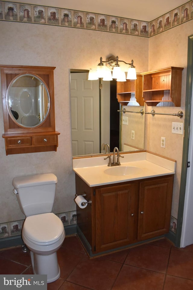 bathroom with tile patterned flooring, vanity, and toilet