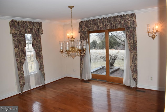 unfurnished dining area with hardwood / wood-style flooring, ornamental molding, and a chandelier